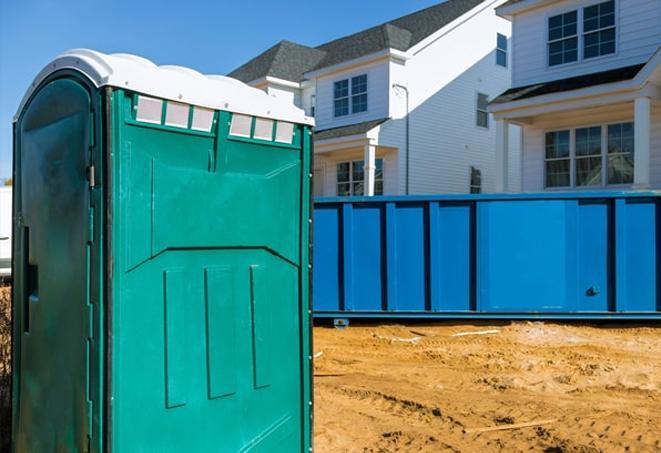 a row of blue and white porta potties on a busy work site